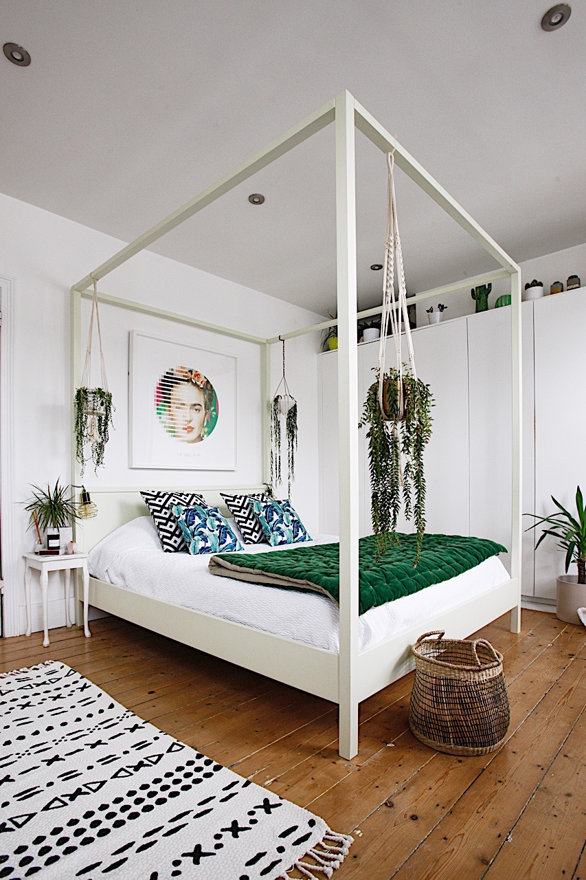 Botanical bedroom with white and green decor and canopy bed